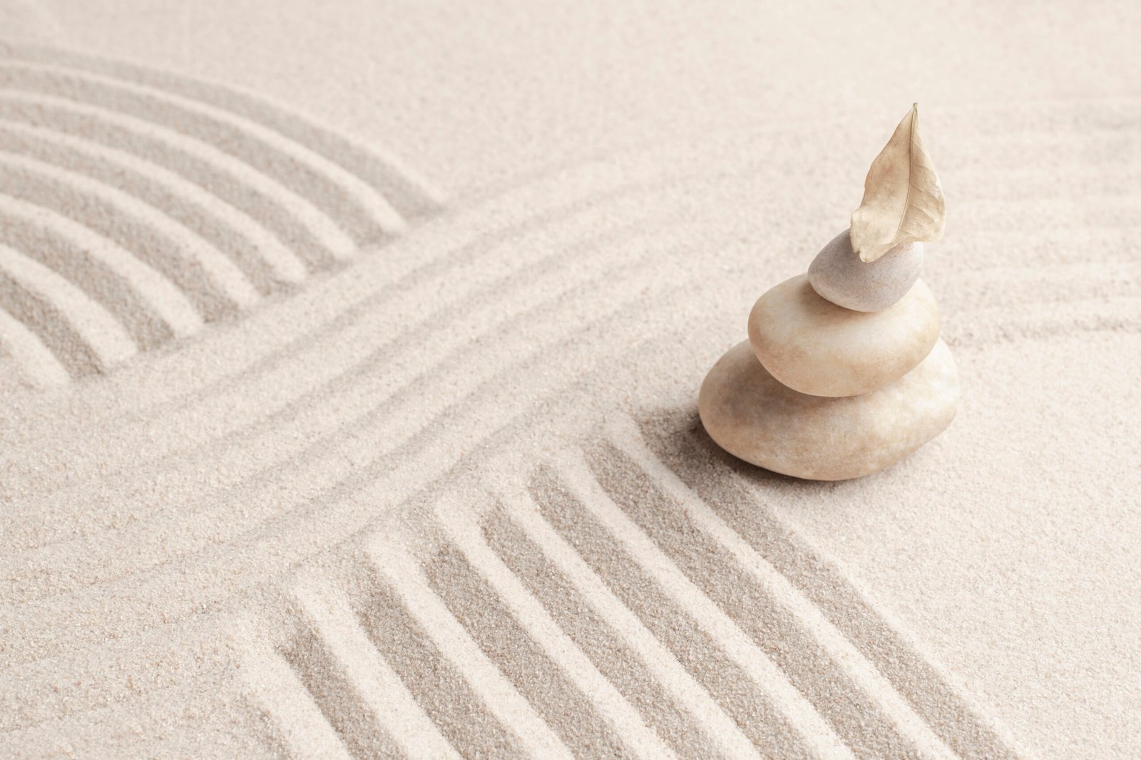 Stacked zen rocks in raked sand symbolizing how cleaning a very messy room with ADHD can become a calm, focused, and stress-free experience.